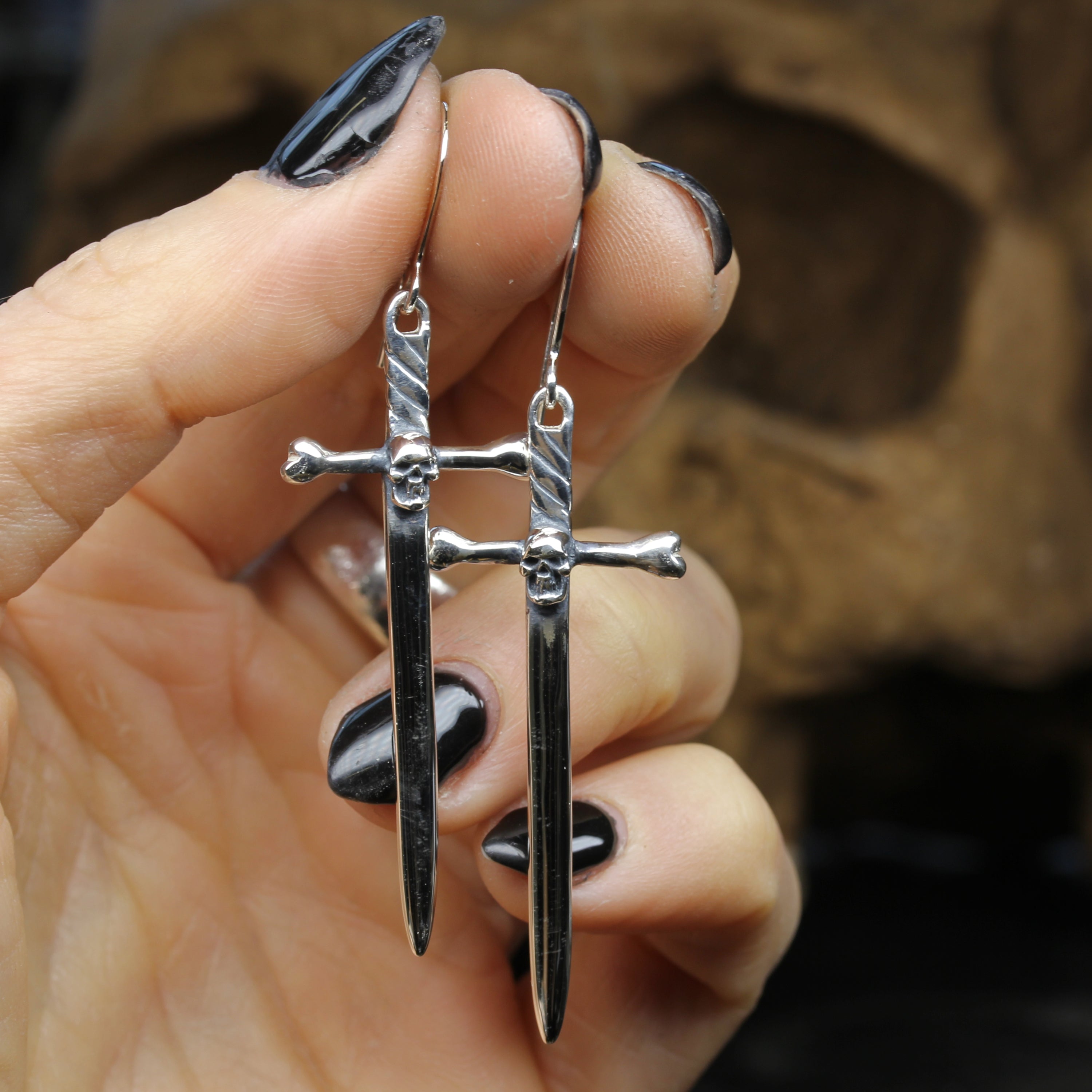 Silver Sword Earrings Held in Hand