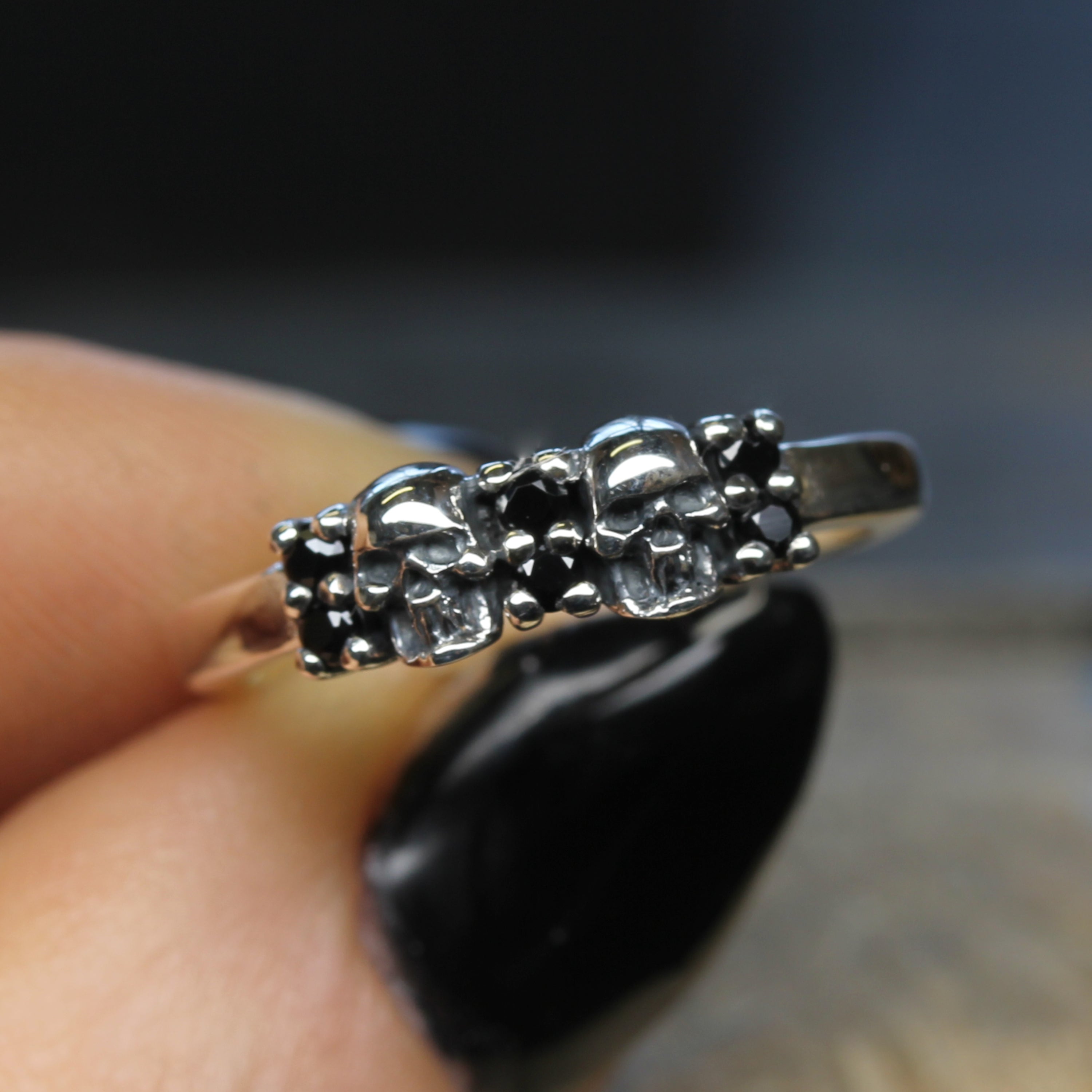 Double Skull Wedding Ring, held in hand